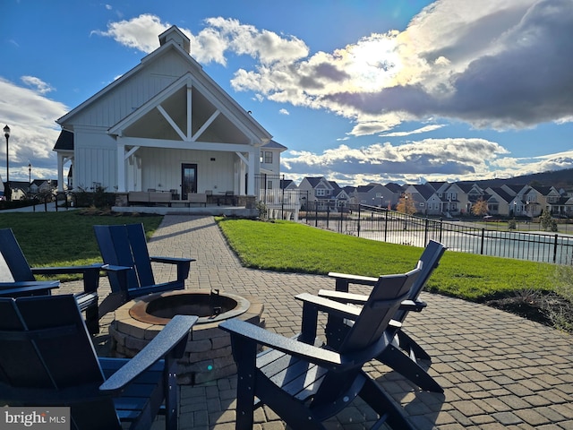 view of patio / terrace featuring an outdoor fire pit and a water view