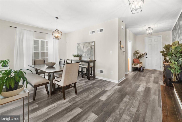 dining area featuring a notable chandelier and dark hardwood / wood-style flooring