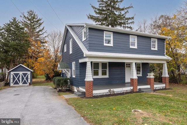 view of front facade with a porch, a front lawn, and a storage shed