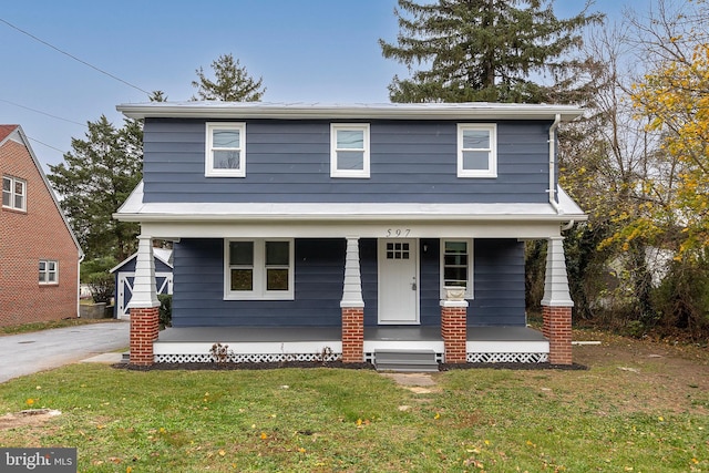 front facade with covered porch and a front yard