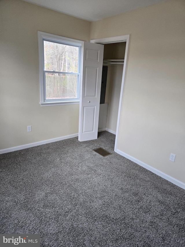 unfurnished bedroom featuring carpet floors and a closet