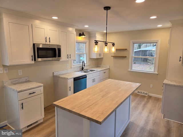 kitchen with white cabinets, plenty of natural light, a center island, and stainless steel appliances