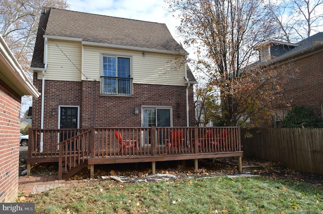 back of property with a yard and a wooden deck