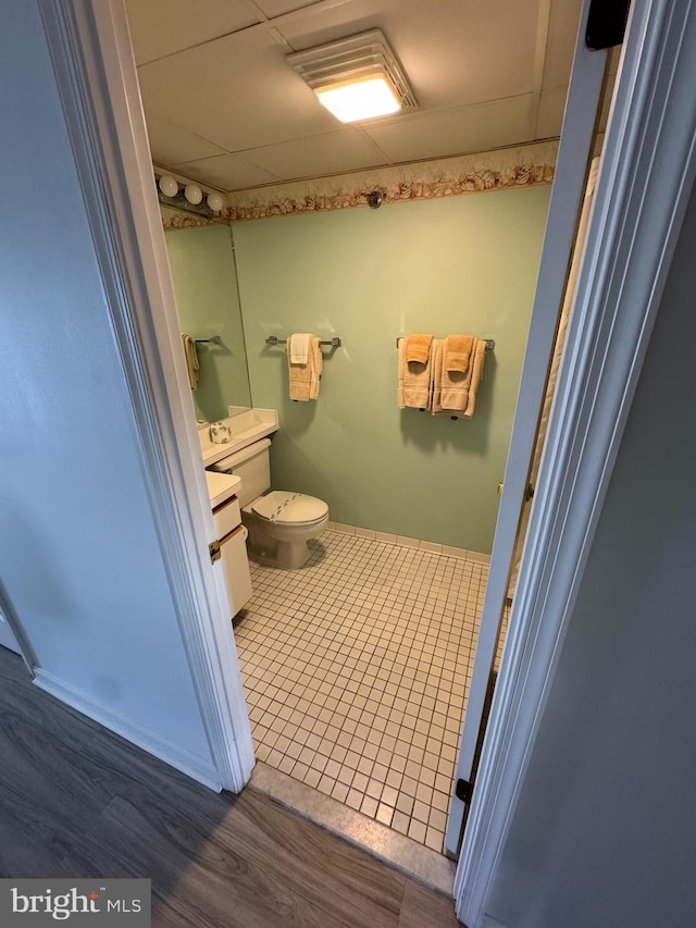 bathroom featuring a paneled ceiling, toilet, vanity, and hardwood / wood-style flooring