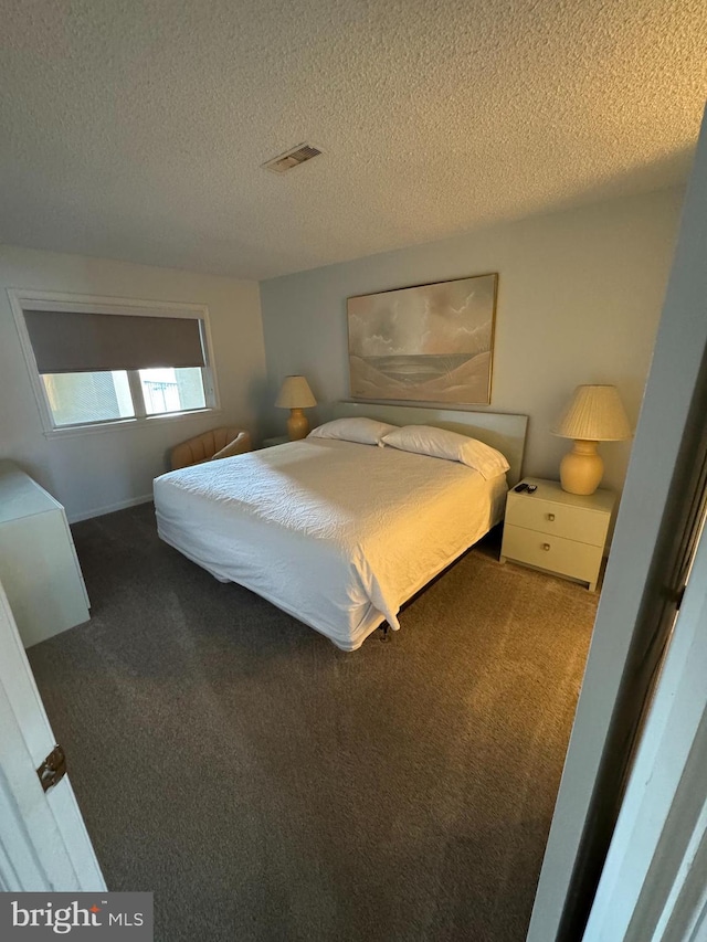 bedroom featuring carpet and a textured ceiling