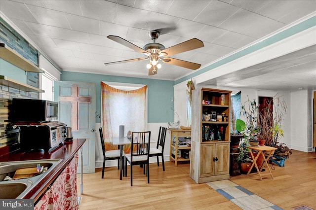 kitchen with sink, crown molding, light hardwood / wood-style floors, and ceiling fan