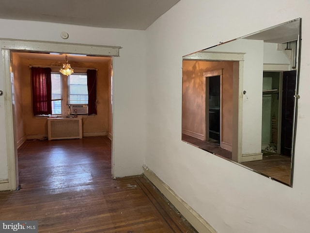 hall featuring radiator heating unit, cooling unit, dark wood-type flooring, and an inviting chandelier