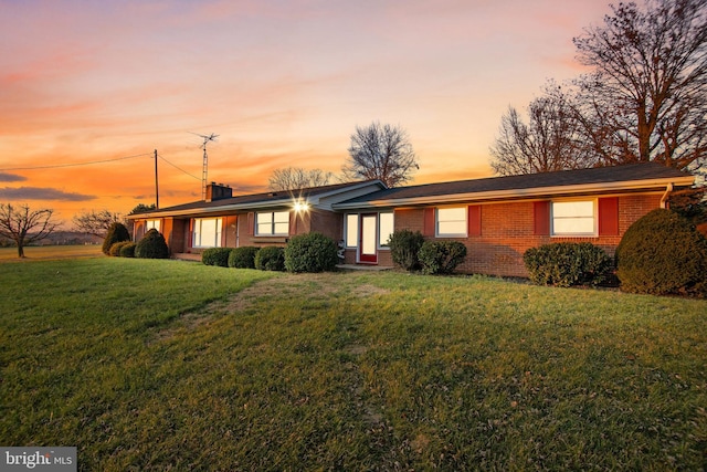 ranch-style home with brick siding and a lawn