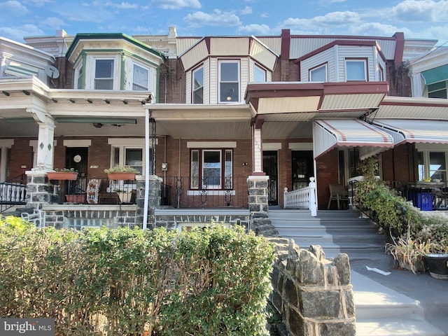 townhome / multi-family property featuring covered porch