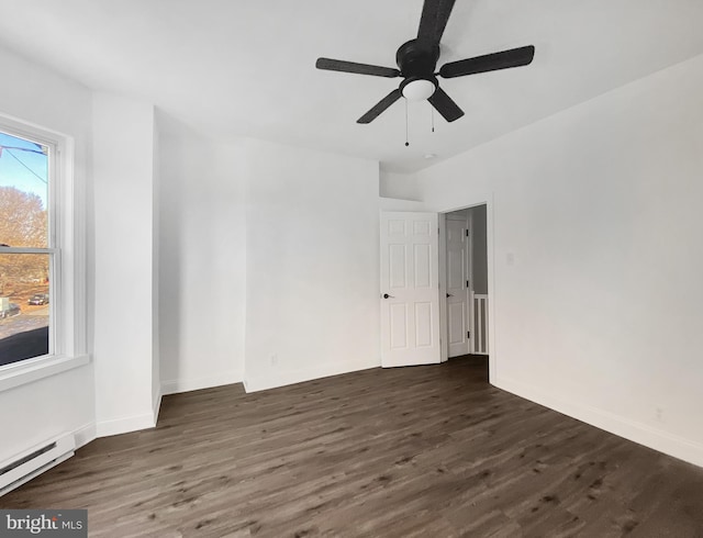 spare room featuring dark hardwood / wood-style floors, ceiling fan, and a baseboard heating unit