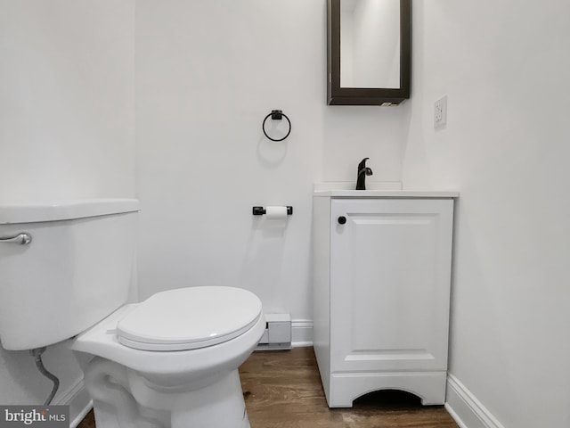 bathroom with hardwood / wood-style flooring, vanity, and toilet