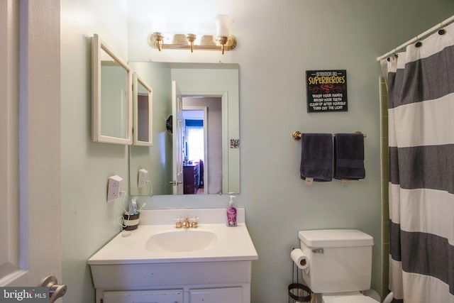 bathroom with a shower with curtain, vanity, and toilet