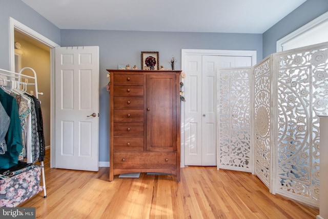 bedroom with light wood-type flooring and a closet