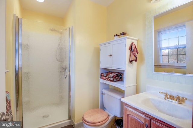 bathroom with vanity, toilet, and a shower with shower door