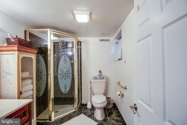 bathroom featuring vanity, an enclosed shower, and toilet