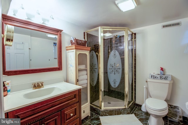 bathroom with vanity, a shower with shower door, and toilet