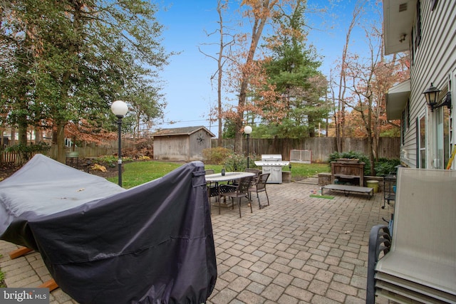 view of patio featuring a grill and a storage shed