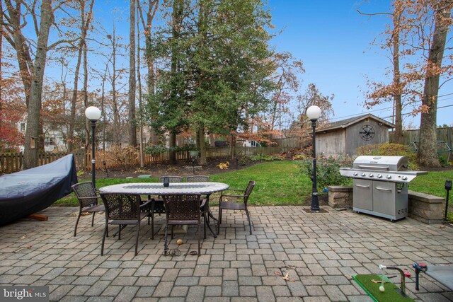 view of patio / terrace with a grill and a storage unit