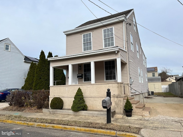 view of front of property with a porch, central AC unit, and a storage unit