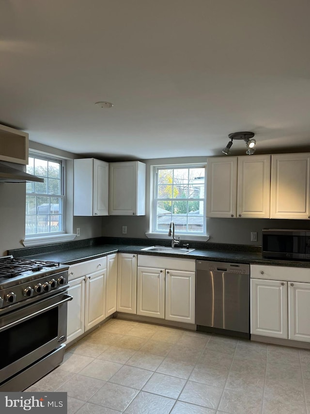 kitchen with white cabinets, sink, stainless steel appliances, and a wealth of natural light