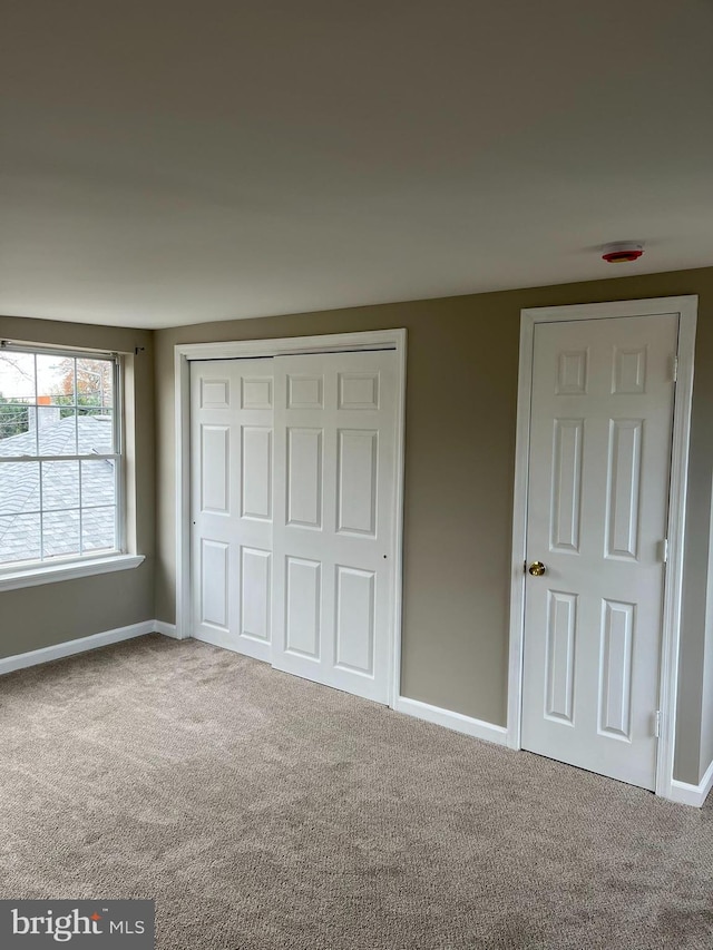 unfurnished bedroom with carpet flooring and a closet