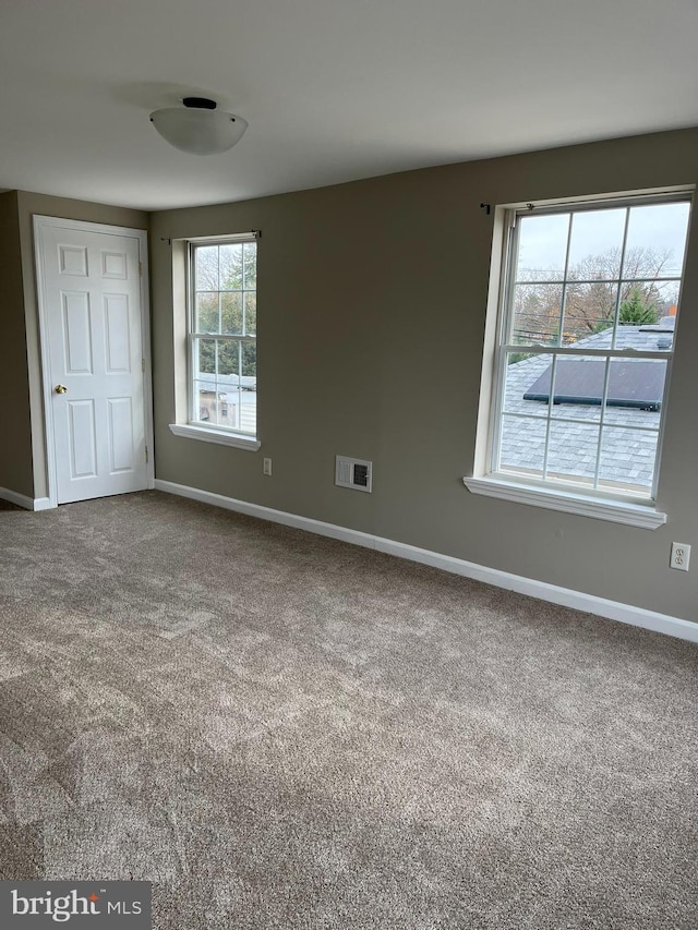 unfurnished bedroom with multiple windows and carpet floors