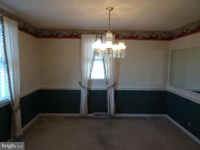 unfurnished dining area featuring a notable chandelier