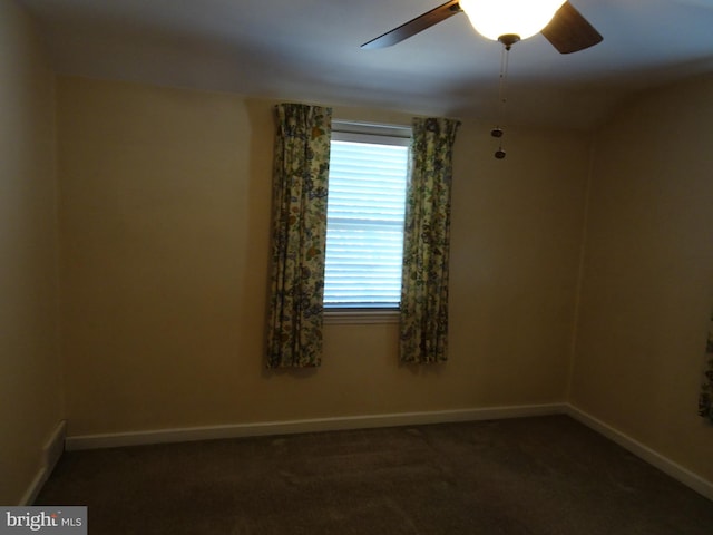 spare room with dark carpet and ceiling fan