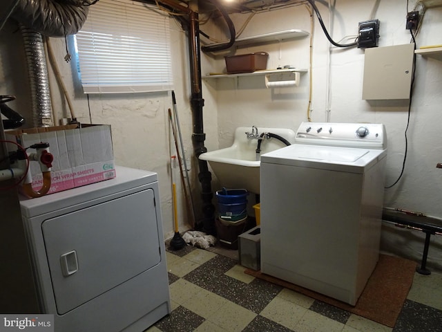 clothes washing area with washer and clothes dryer and sink