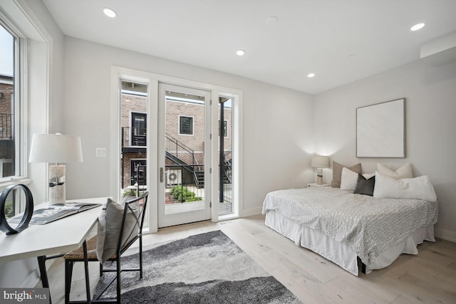 bedroom featuring access to outside, light hardwood / wood-style flooring, and multiple windows