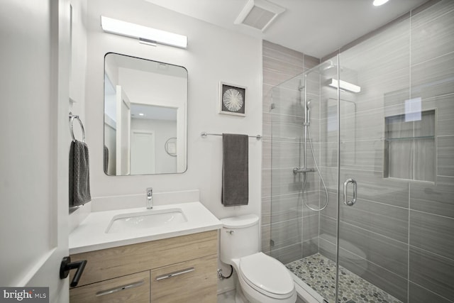 bathroom with vanity, an enclosed shower, and toilet