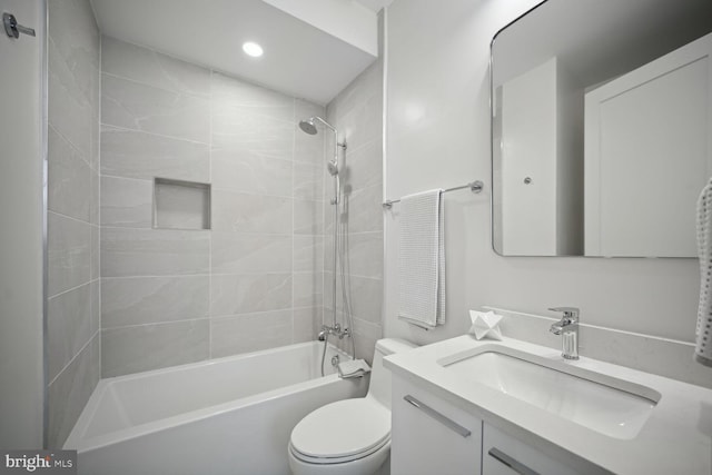 full bathroom featuring vanity, tiled shower / bath combo, and toilet