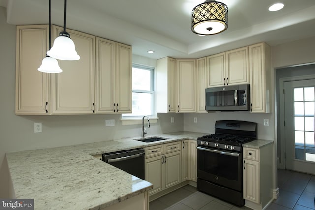 kitchen with cream cabinets, sink, light stone countertops, decorative light fixtures, and stainless steel appliances