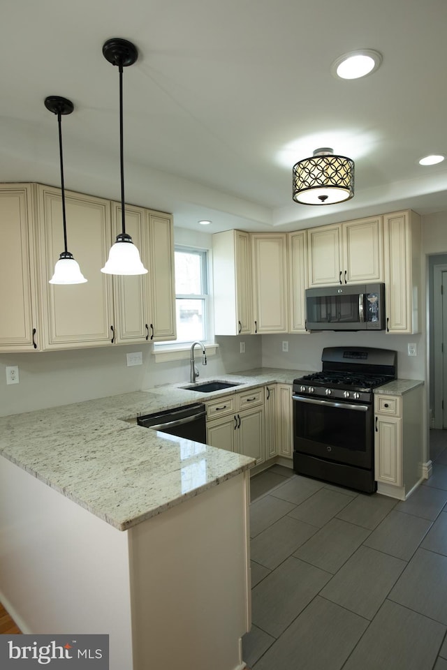 kitchen with black appliances, sink, light stone countertops, decorative light fixtures, and kitchen peninsula