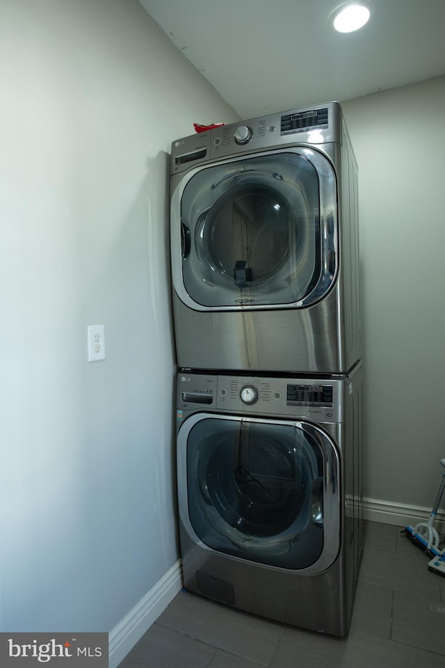 laundry area with tile patterned floors and stacked washer and clothes dryer