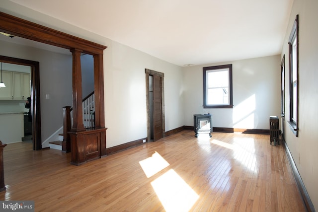 spare room featuring hardwood / wood-style floors, radiator heating unit, and a wood stove