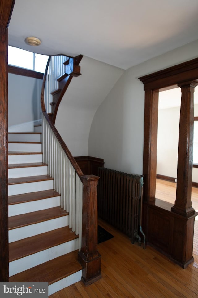 staircase with hardwood / wood-style flooring and radiator