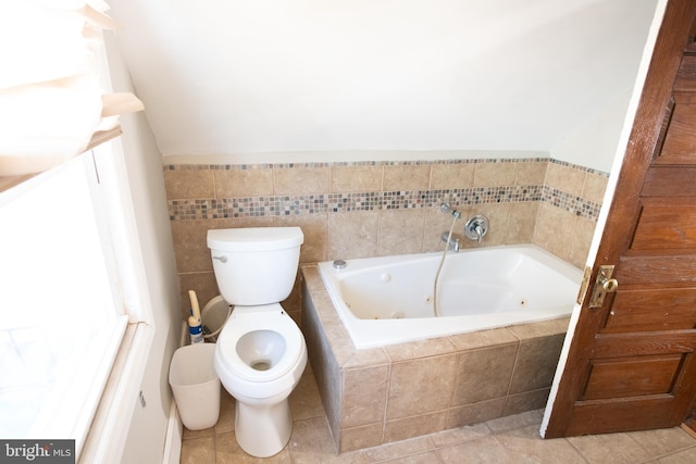 bathroom with vanity, tile walls, tile patterned flooring, tiled bath, and toilet