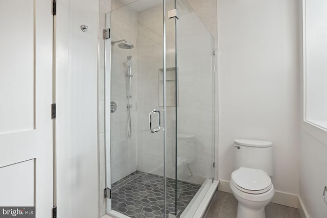 bathroom featuring an enclosed shower and toilet