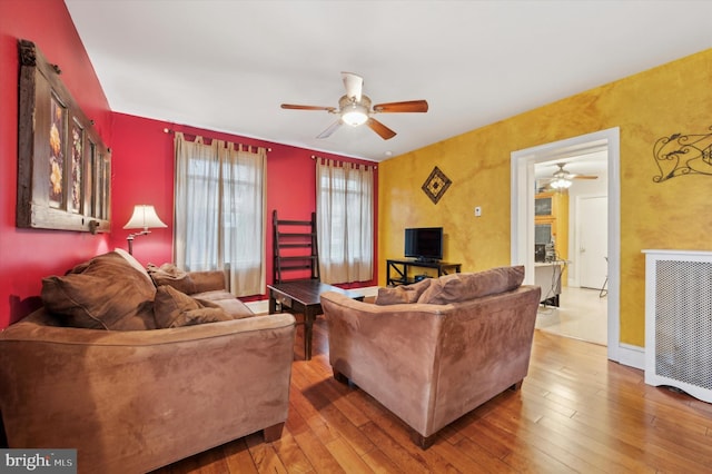 living room featuring ceiling fan and wood-type flooring