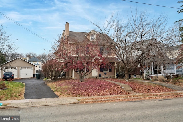 view of front facade featuring a garage and an outbuilding