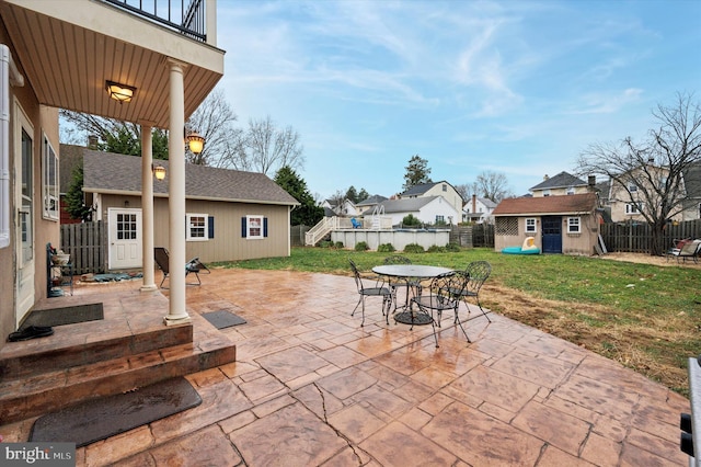 view of patio featuring a balcony and a shed