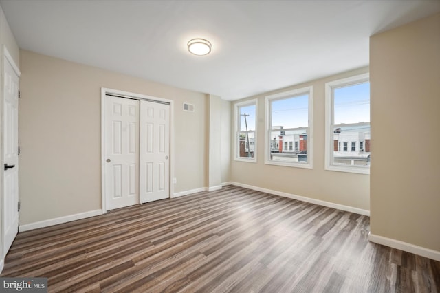 unfurnished bedroom featuring dark hardwood / wood-style flooring and a closet