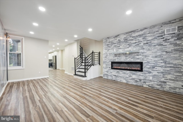 unfurnished living room featuring a large fireplace and hardwood / wood-style flooring