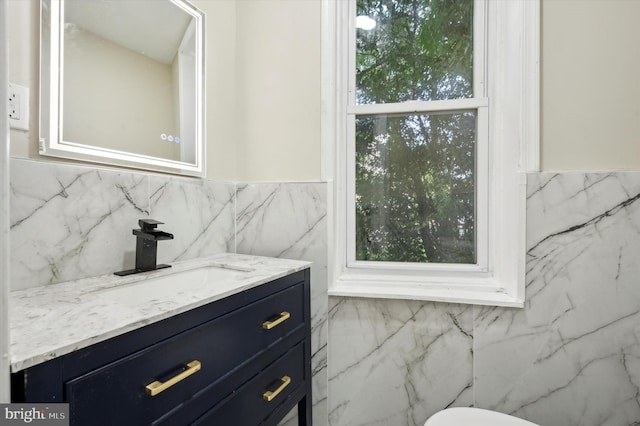 bathroom with vanity and tile walls