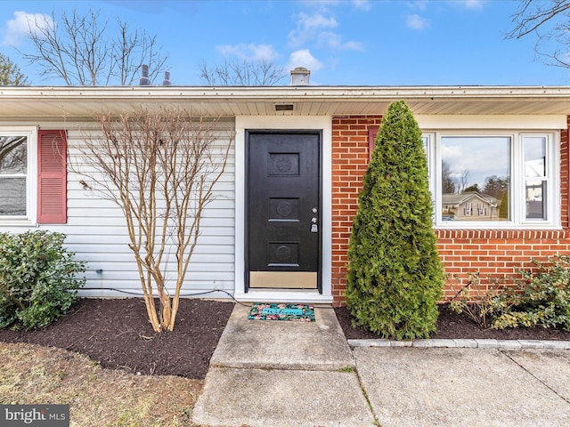 view of exterior entry with brick siding