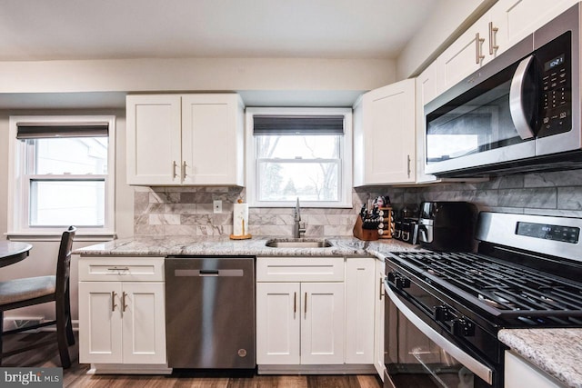 kitchen featuring plenty of natural light, sink, white cabinetry, and stainless steel appliances