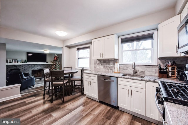 kitchen featuring white cabinetry, sink, stainless steel appliances, and wood-type flooring