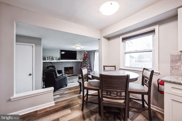 dining room with a fireplace and hardwood / wood-style floors