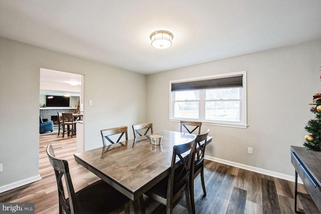 dining area with a fireplace and hardwood / wood-style floors